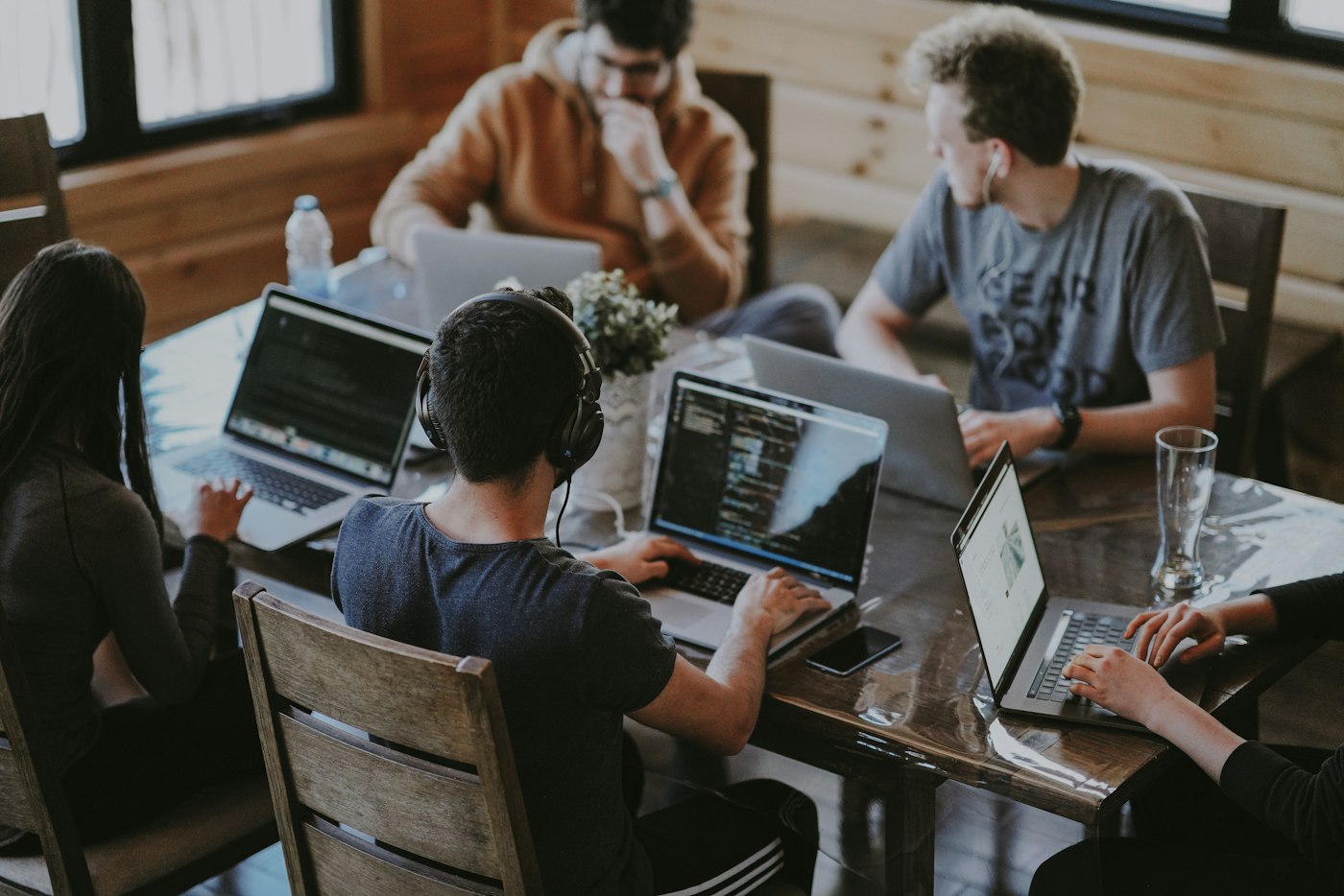 Colleagues working together around a table with laptops